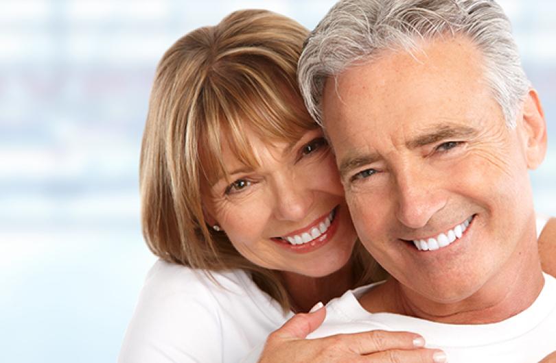 An older adult couple cheek to cheek